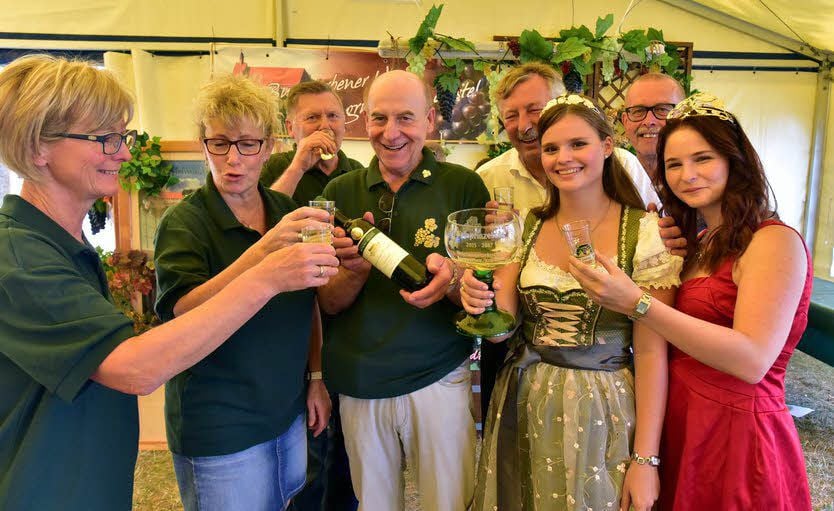Weinkönigin Sandra Warzeschka (rechts) und die Burgwerbener Weinprinzessin Gina Maria Gräfe (2. von rechts) stoßen mit den Gästen an.