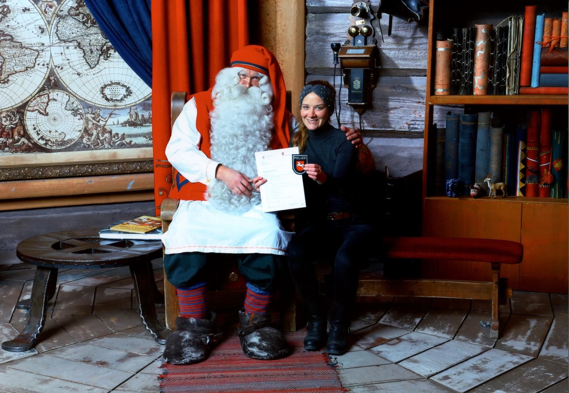 Die niedersächsische Polizeibeamtin Lena Krüger überreicht dem Weihnachtsmann eine Wunschliste für Weihnachten.