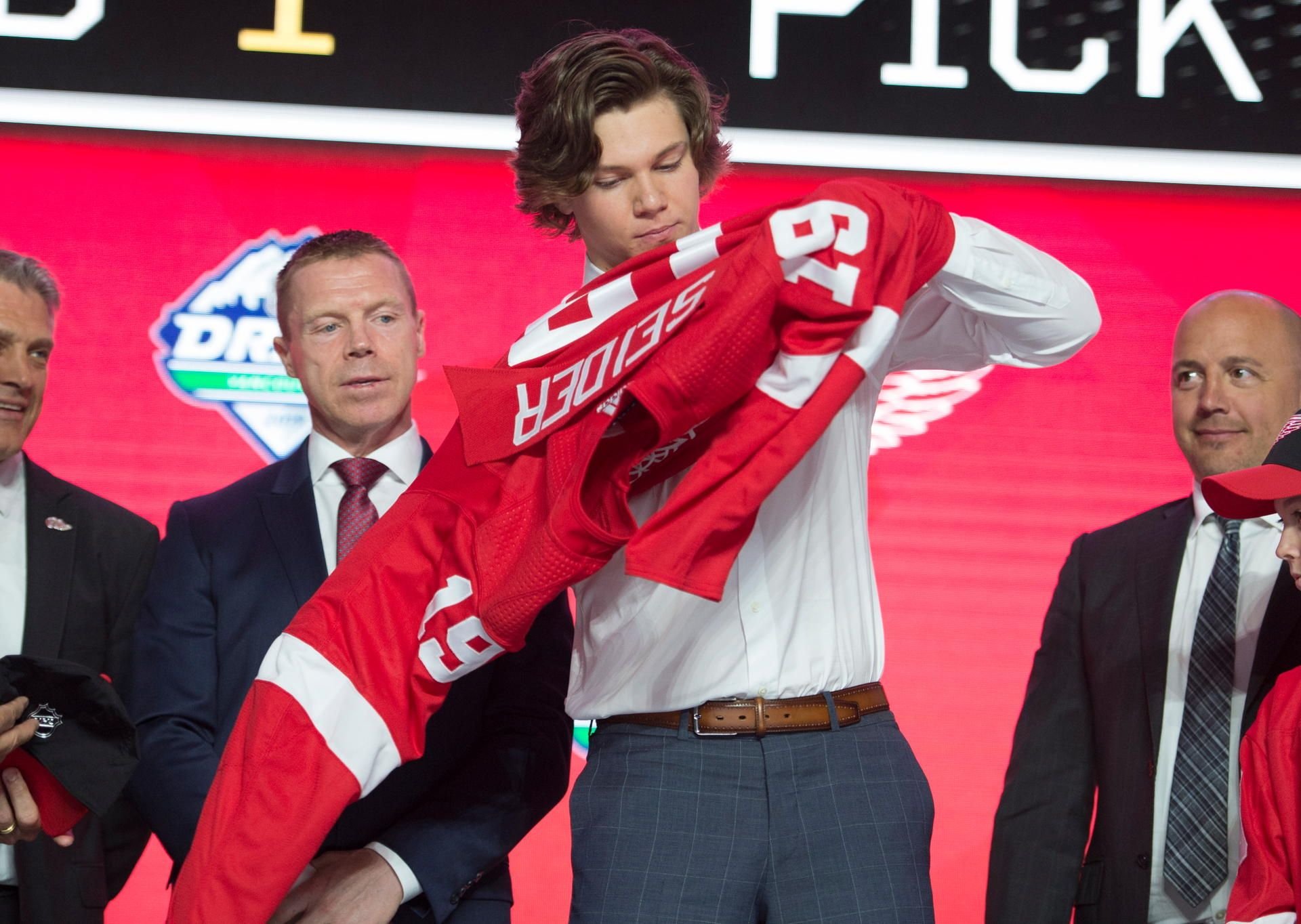 Moritz Seider streift sich stolz sein neues Trikot der Detroit Red Wings über.
