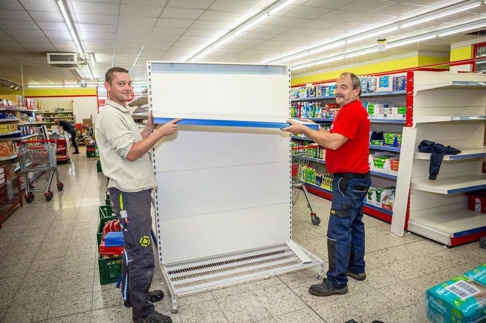 Während Sandro Hansen (l.) und Stephan Irmler noch einige Regalsysteme aufbauen, werden diese in anderen Gängen schon eingeräumt.