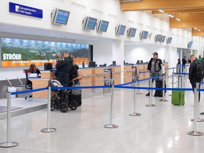Fluggäste mit Gepäck stehen beim Check-In im Flughafenterminal am Kassel Airport. Foto: Swen Pförtner/dpa/Archiv