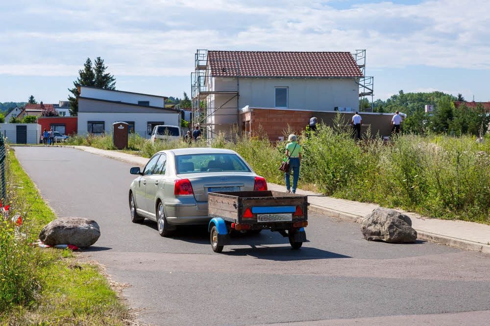 Findlinge, die jüngst mitten auf der Straße lagen, liegen nun am Rand. Autofahrer sagen, sie könnten zur Gefahr werden.