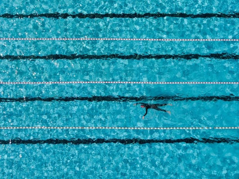 Ein Badegast in einem 50-Meter-Becken. Foto: Axel Heimken/dpa/Symbolbild