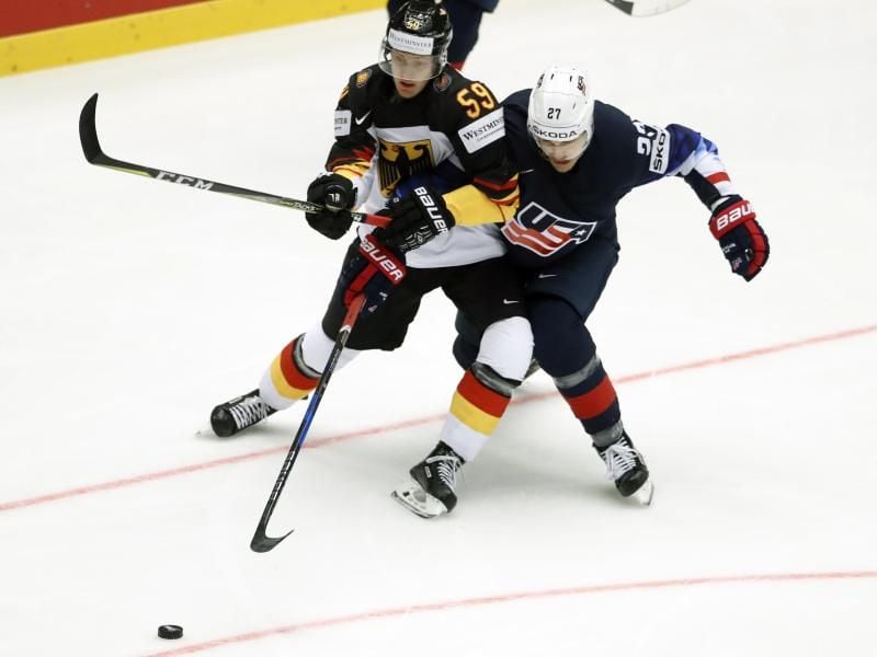 Anders Lee (r) kämpft gegen DEB-Spieler Manuel Wiederer um den Puck. Foto: Petr David Josek/AP