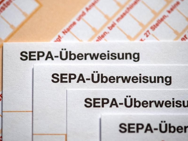 Mehrere Sepa-Überweisungsträger liegen übereinander. Foto: Fabian Sommer/Archiv