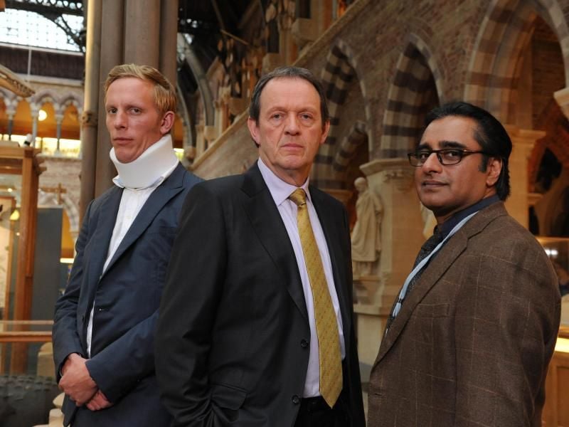 DI Lewis (Kevin Whately, M.) und DS James Hathaway (Laurence Fox, l.) haben den Eindruck, dass Kanan Dutta (Sanjeev Bhaskar, r.) mehr über den ermordeten Geisterseher weiß, als er zuzugeben bereit ist Foto: Robert Day/ZDF