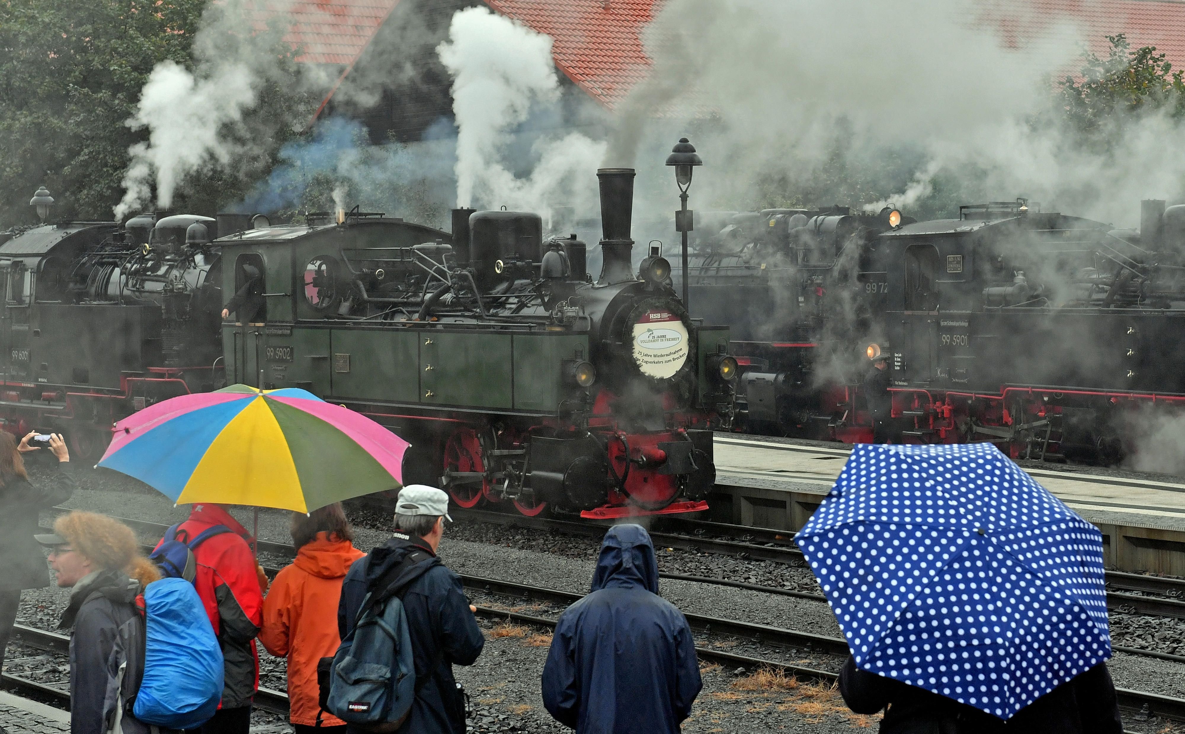 Besucher im Bahnhof von Wernigerode (Sachsen-Anhalt) werfen am 17.09.2016 einen Blick auf die dampfenden Lokomotiven der Harzer Schmalspurbahnen (HSB) mit dem Jubiläumszug links im Bild.