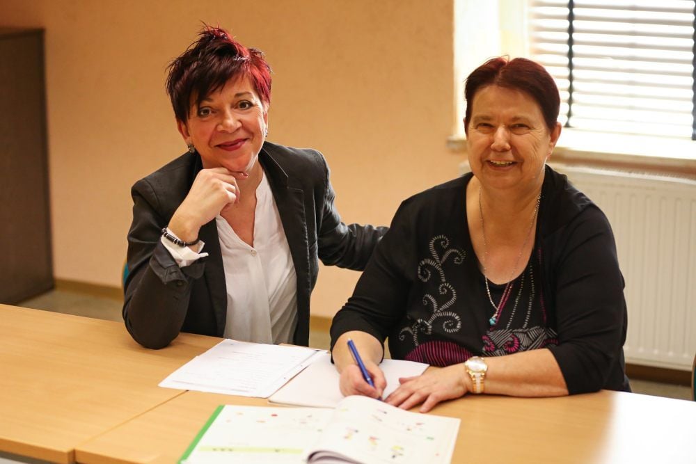 Astrid Gläser (l.), Außenstellenleiterin der Kreisvolkshochschule in Querfurt, führt mit der 62-jährigen Annerose Lautenschläger eine Schreibübung durch.