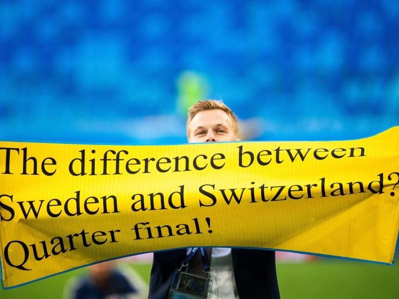 Der Schwede Sebastian Larsson hält nach dem Spiel ein Plakat hoch mit der Aufschrift : „The difference between Sweden and Switzerland? Quarter final!” Foto: Joel Marklund/Bildbyran via ZUMA Press