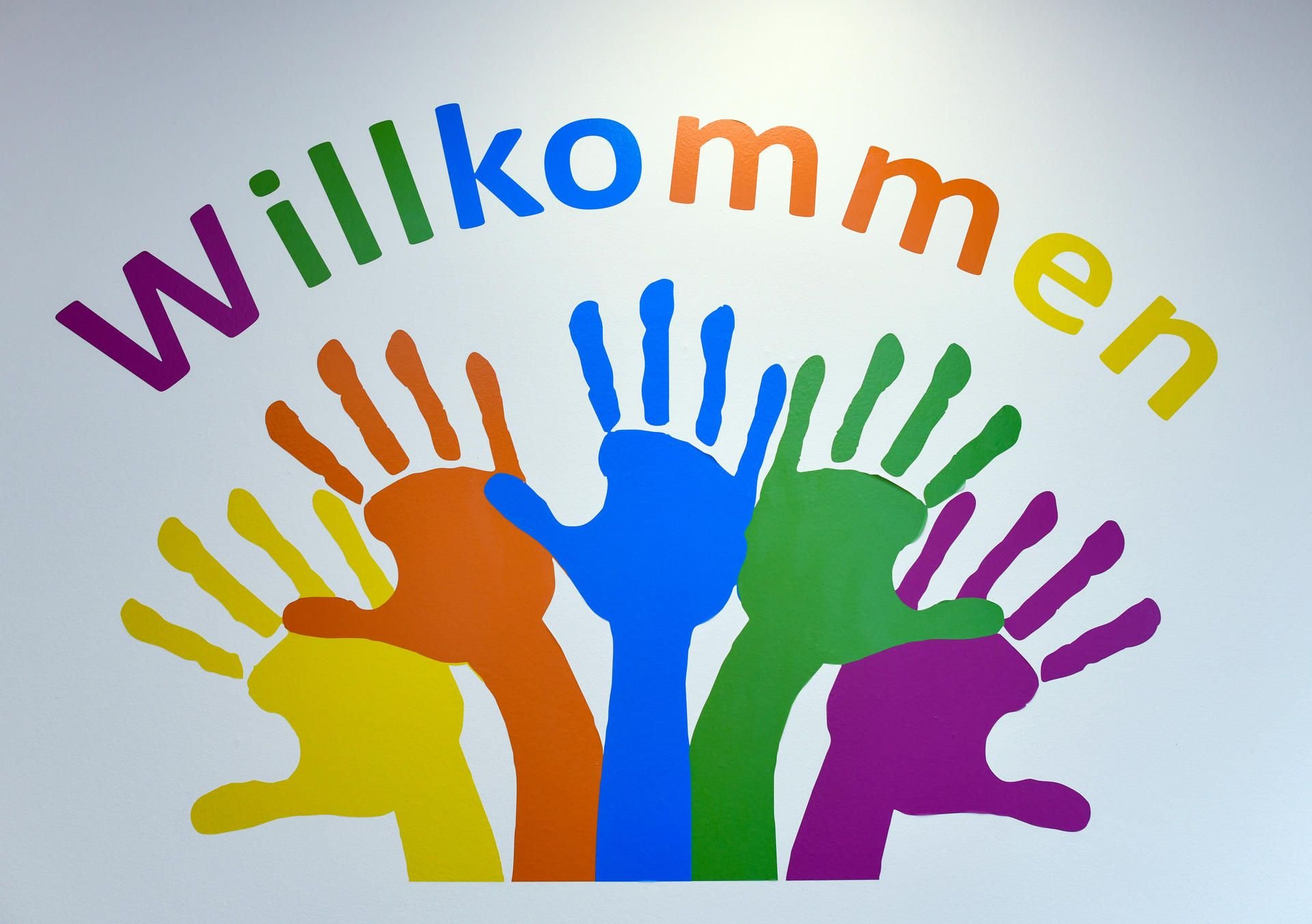 Bunte Hände und das Wort «Willkommen» zieren eine Wand. Viele Asylbewerber kamen auf dem Weg über andere europäische Länder nach Deutschland. Aus Furcht vor Abschiebung in diese Länder suchen manche von ihnen Schutz in einer Kirche.