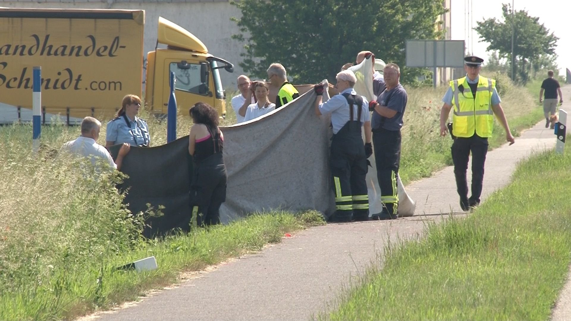Feuerwehrleute schirmen mit einer Plane den Unfallort in Hohendodeleben (Landkreis Börde) ab.