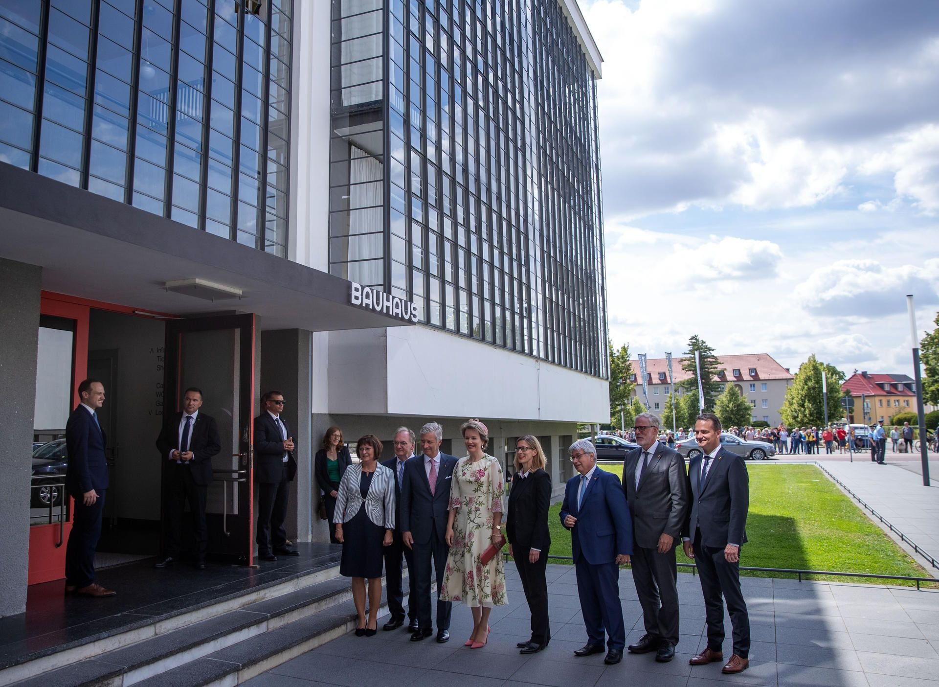 Das belgische Königspaar König Philippe und Königin Mathilde stehen mit Reiner Haseloff (CDU, 2.v.l.), Sachsen-Anhalts Ministerpräsident, und seiner Frau Gabriele Haseloff (l) vor dem Haupteingang zum Bauhaus.