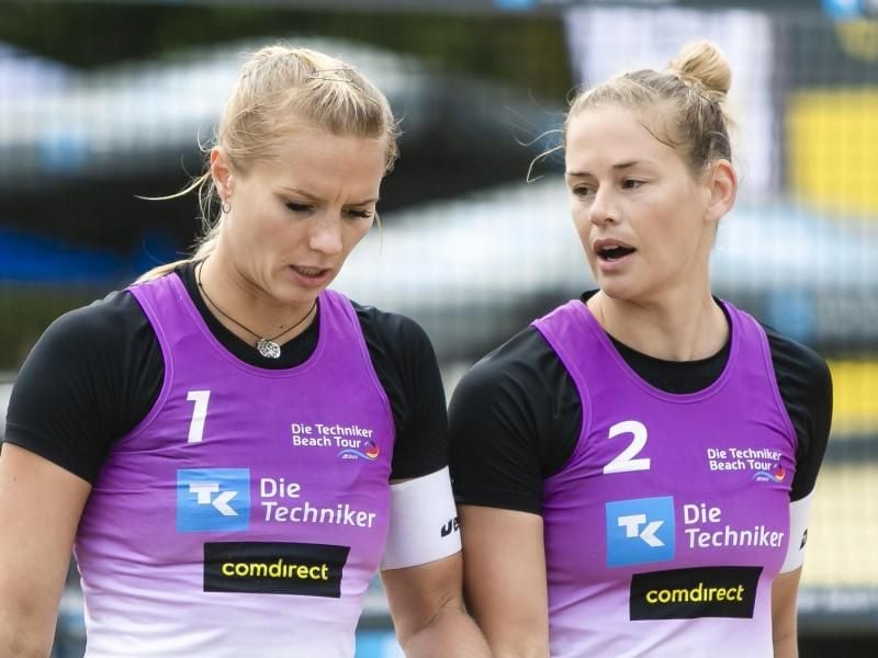 Kim Behrens (l) und Cinja Tillmann unterhalten sich bei den Deutschen Beachvolleyball-Meisterschaften. Foto: Frank Molter/dpa