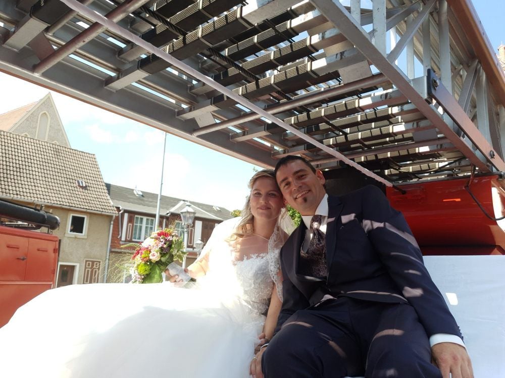 Sebastian Müller und seine Stefanie frisch verheiratet auf dem Thron unter der historischen Drehleiter der Feuerwehr Aken.
