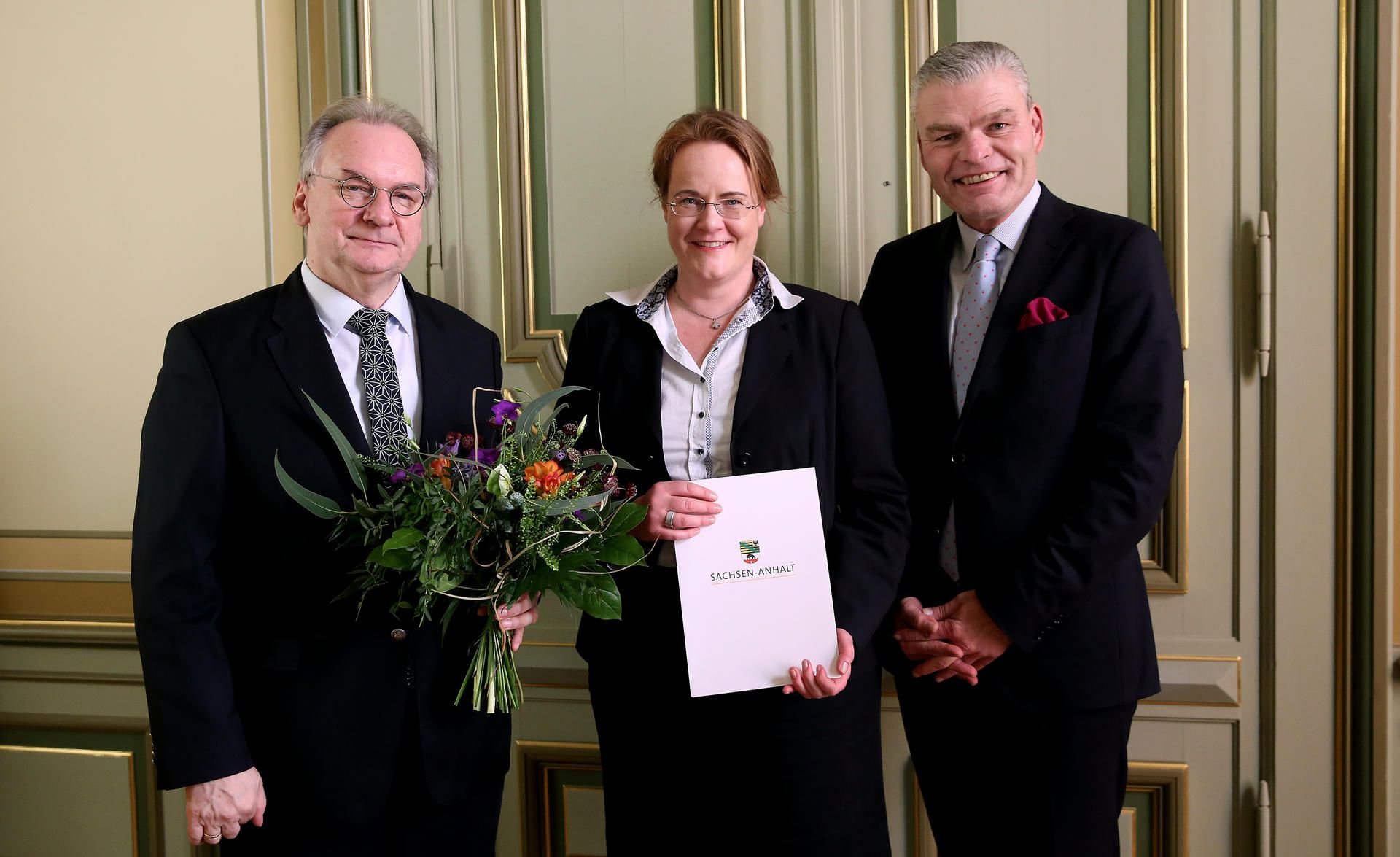 Sachsen-Anhalts Ministerpräsident Reiner Haseloff (l, CDU) und Innenminister Holger Stahlknecht (r., CDU) überreichen die Ernennungsurkunde an die neue Innenstaatssekretärin Anne Poggemann (M.) in der Staatskanzlei.
