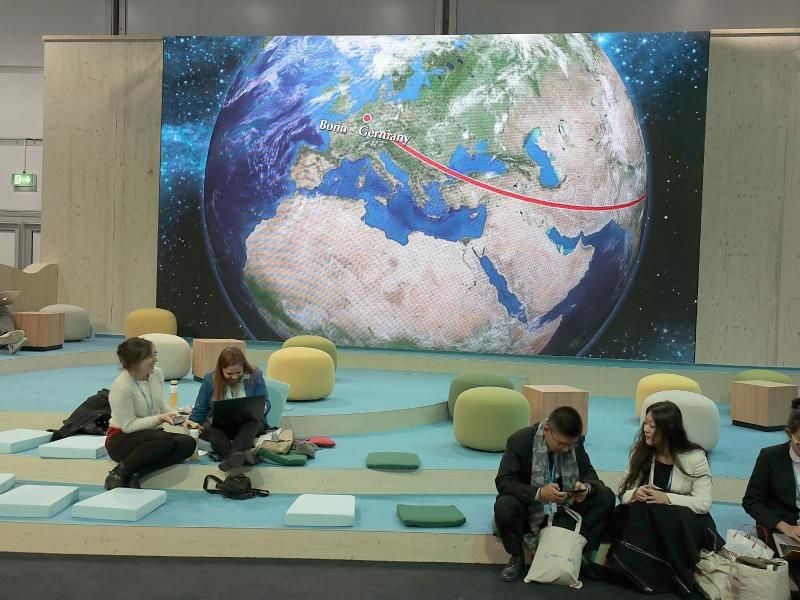 Teilnehmer der Weltklimakonferenz in Bonn sitzen vor der Darstellung einer Weltkugel. Die Delegationen sollen in der zweiten Konferenz-Woche Textentwürfe für ein Regelwerk erarbeiten. Foto: Oliver Berg