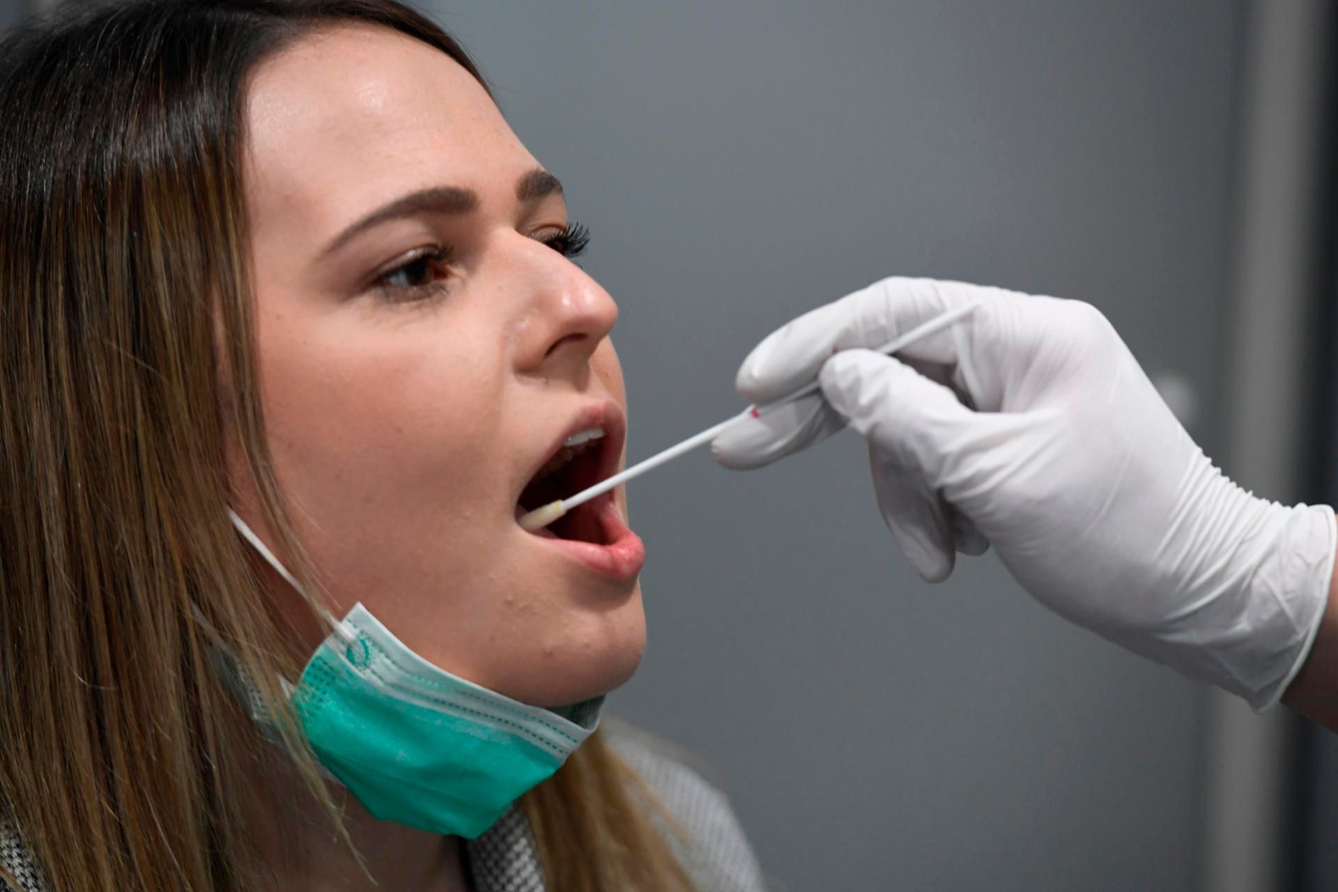 Ein Krankenpfleger demonstriert mit einer Mitarbeiterin den Abstrich bei einer Patientin. In Sachsen-Anhalt steigt die Zahl der Corona-Fälle. (Symbolbild)