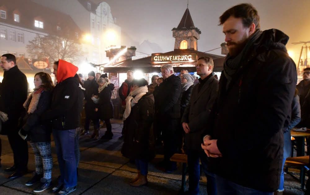 Die Weißenfelser legen am Abend eine Schweigeminute auf dem Weihnachtsmarkt ein.