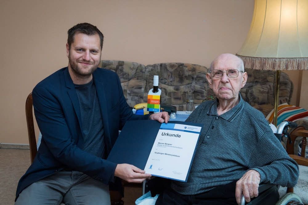Andreas Baer von der Handwerkskammer Halle übergibt an Werner Bergner die Urkunde zum 70-jährigen Meisterjubiläum.