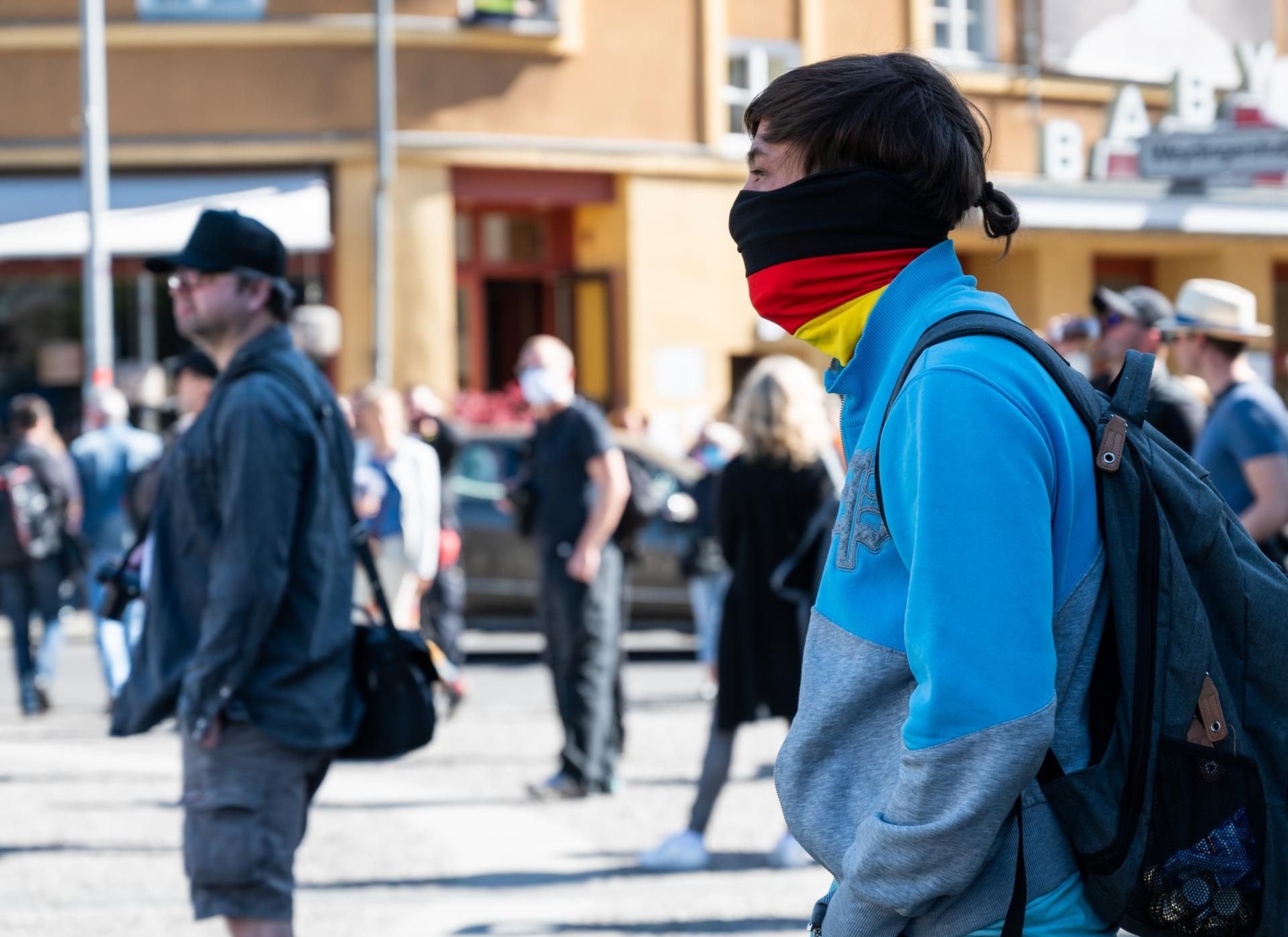Menschen stehen bei einer unerlaubten Demonstration auf dem Rosa-Luxemburg-Platz.