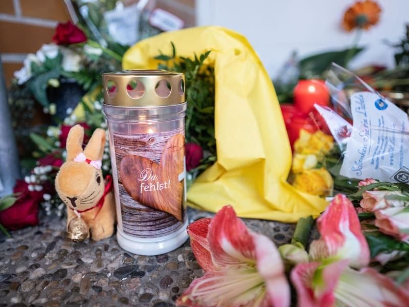 Blumen und Kerzen sind am Eingang der Kindertagesstätte abgelegt. Foto: Frank Rumpenhorst/dpa