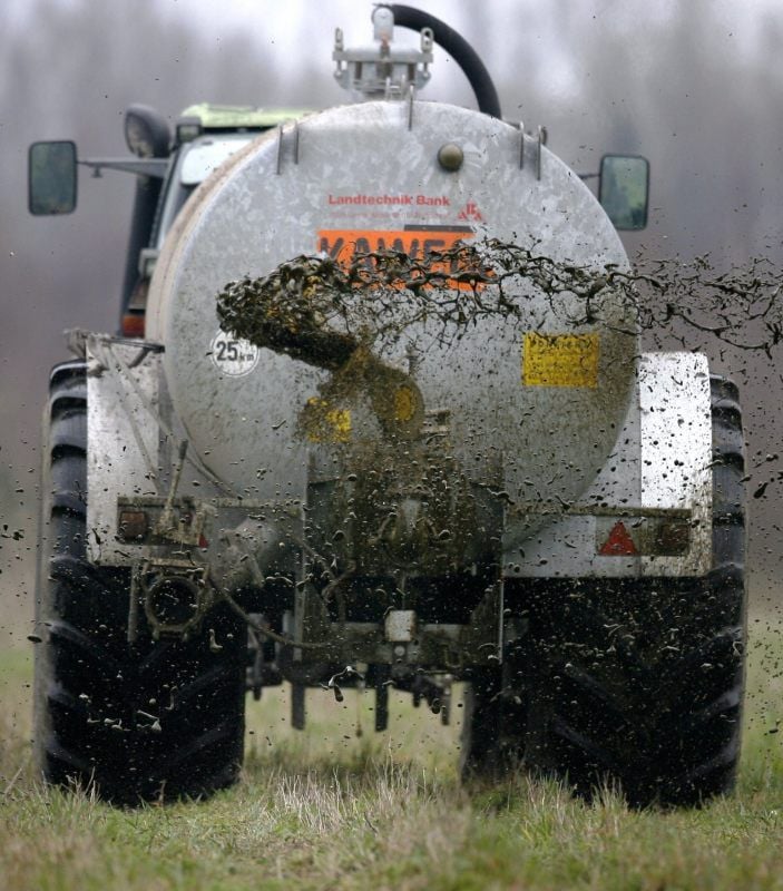 Ein Landwirt bringt Gülle auf einem Feld aus.