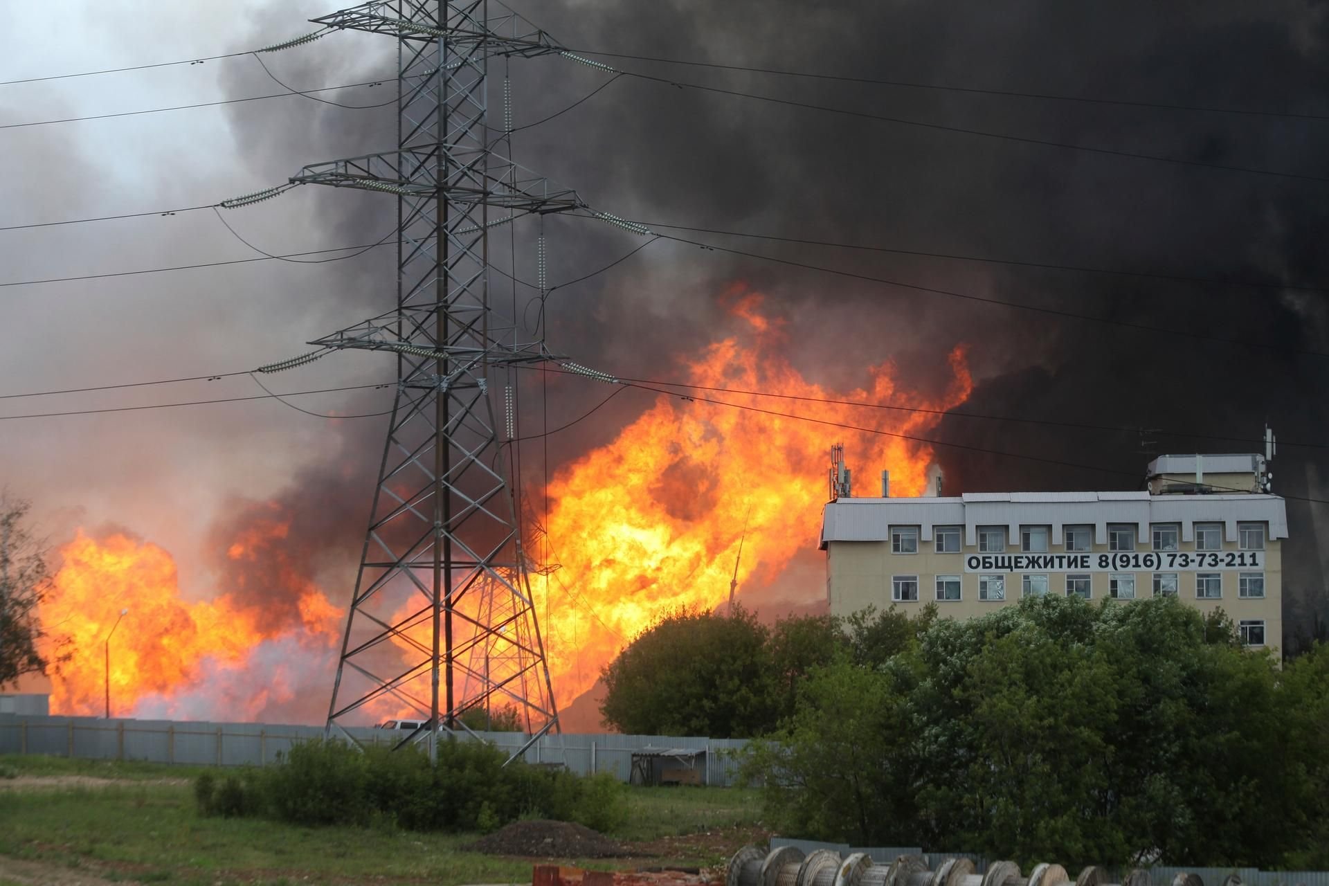 Schwarzer Rauch und Flammen steigen in der Nähe eines Wärmekraftwerks auf.