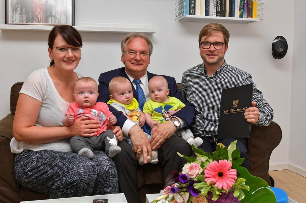 Reiner Haseloff zwischen Denise und Michael Kijas mit den Drillingen Matilda, Jonathan und Leonard.