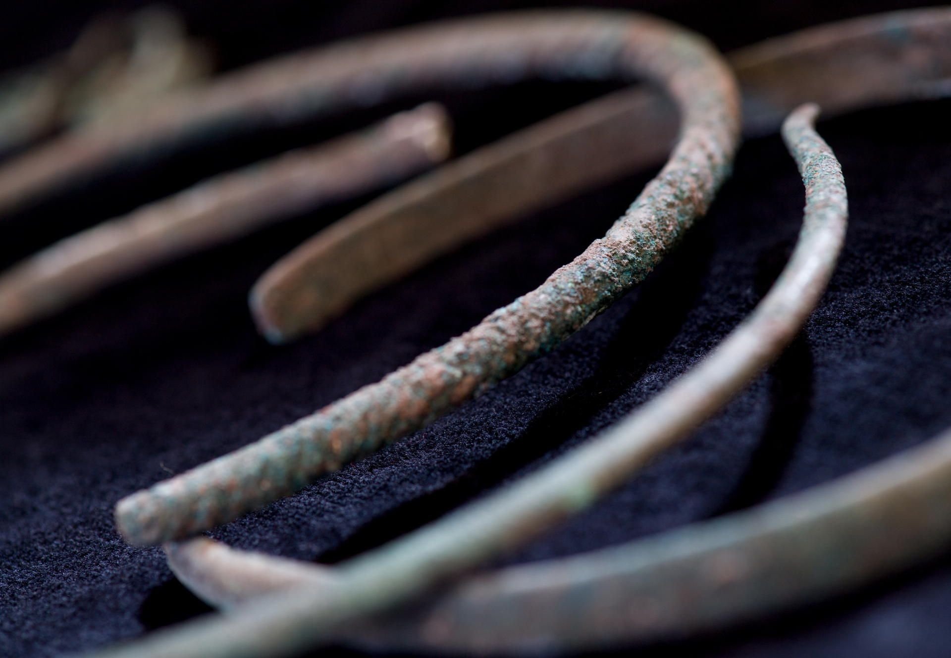 Drei unterschiedlich große Halsringe aus einem bronzezeitlichen Hortfund werden während archäologischer Grabungsarbeiten bei Obhausen gezeigt.
