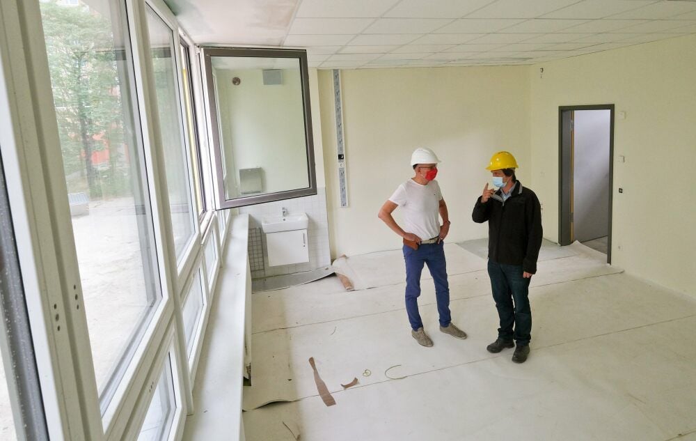 Jan-Ole Prasse (rechts) von der Steuerungsgesellschaft Projectum erklärt Oberbürgermeister Bernd Wiegand die Neuheiten in einem Klassenzimmer.