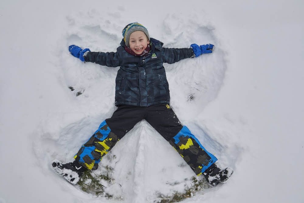 Winter macht Spaß - zumindest Kindern: Der neunjährige Tamo aus Bernburg macht einen Engel im Schnee.