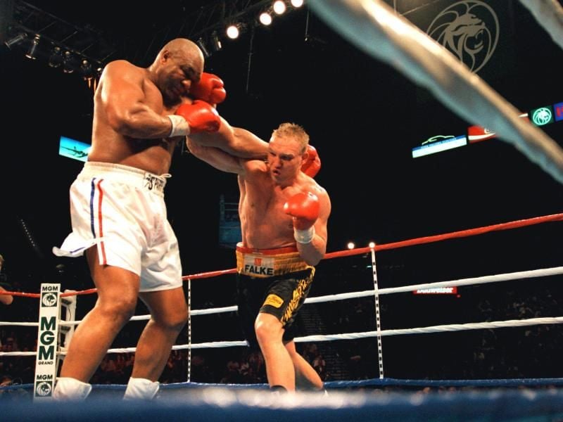 Herausforderer Axel Schulz (r) landet einen Treffer bei Titelverteidiger George Foreman. Foto: Carsten Rehder/dpa