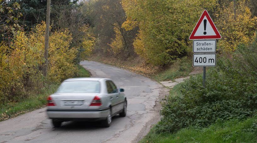 Durch den schlechten Zustand der Straße und dem daraus resultierenden Ausweichen der Autos wird der Spaziergang entlang der Strecke gefährlich.