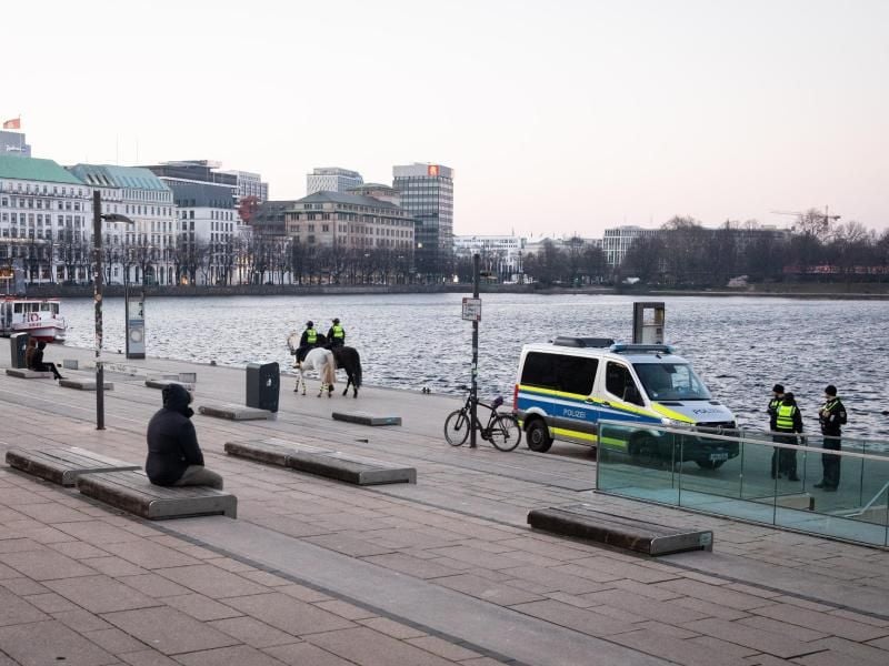 Nur wenige Menschen sind am Jungfernstieg unterwegs, außer Polizeibeamten zu Pferd. Foto: Christian Charisius/dpa