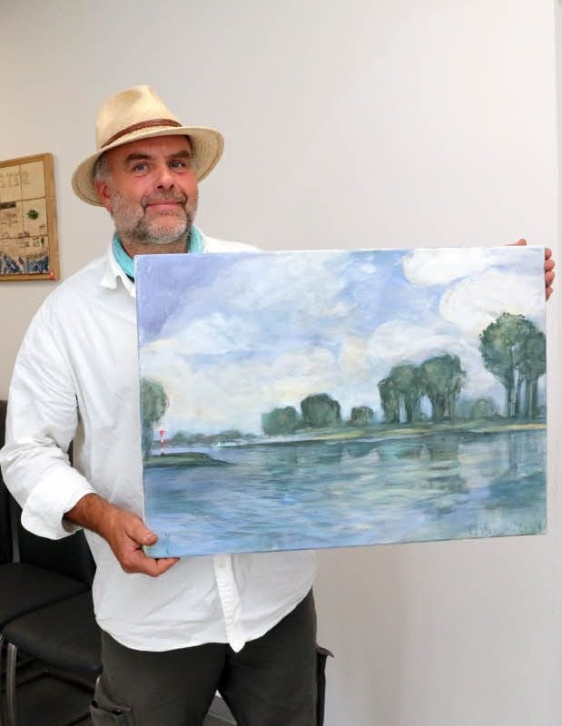 Peter Stechert hat im Rathaus Elster begonnen, seine Bilder aufzuhängen. Darunter ist auch sein jüngstes Werk: ein Blick auf die Elblandschaft und die Fähre.