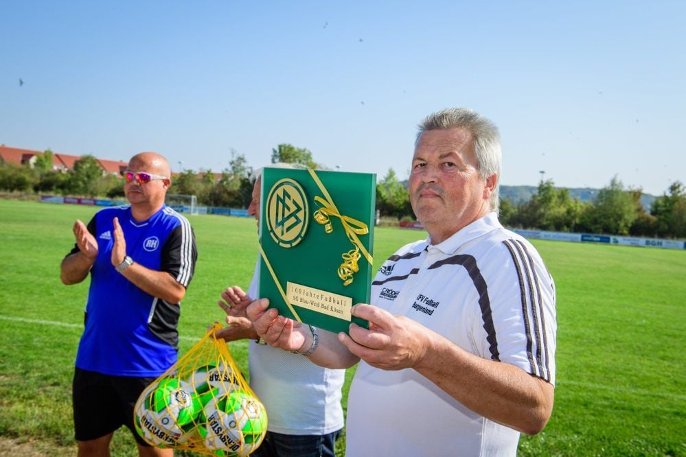 Thomas Reichert, der Präsident des Kreisfußballverbandes, präsentiert das edle DFB-Relief zum runden Geburtstag.