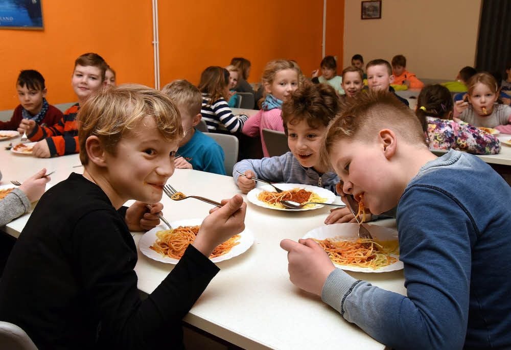 Benny Krosse (l.), Willi Töpfer (r.) und Ringo Gerber lassen sich die Spaghetti schmecken. 95 Prozent der Osterfelder Grundschüler essen mit.