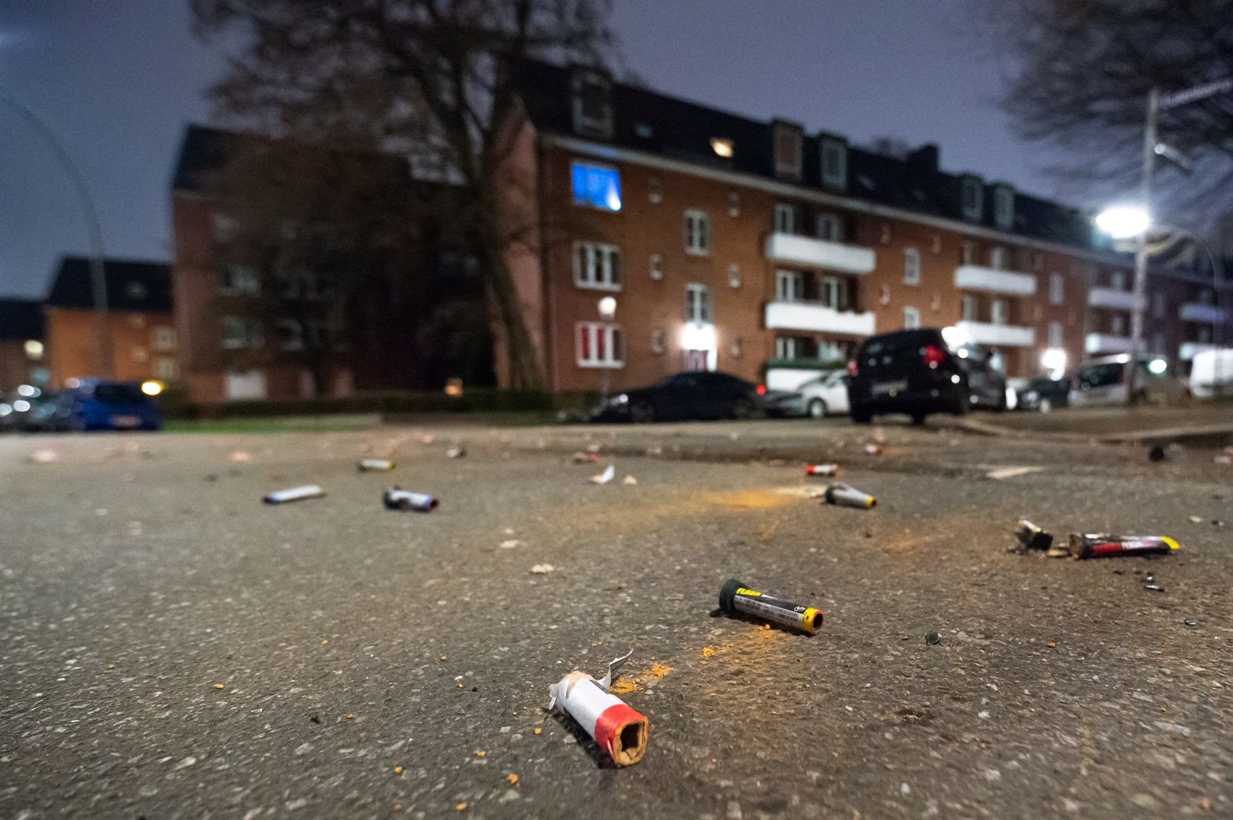 Explodierte Böller- und Raketenteile liegen auf der Straße in einem Wohngebiet.