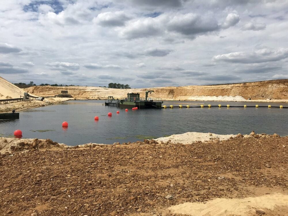 Mit Hilfe eines neu in Betrieb genommenen Saugbaggers wird der Quarzsandstein unter der Wasseroberfläche abgebaut.