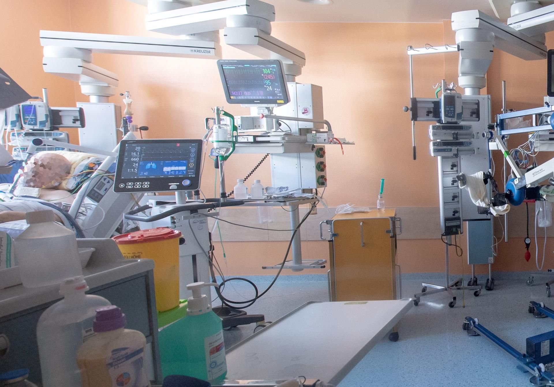 Ein Corona-Patient liegt in einem isoliertem Intensivbett-Zimmer.