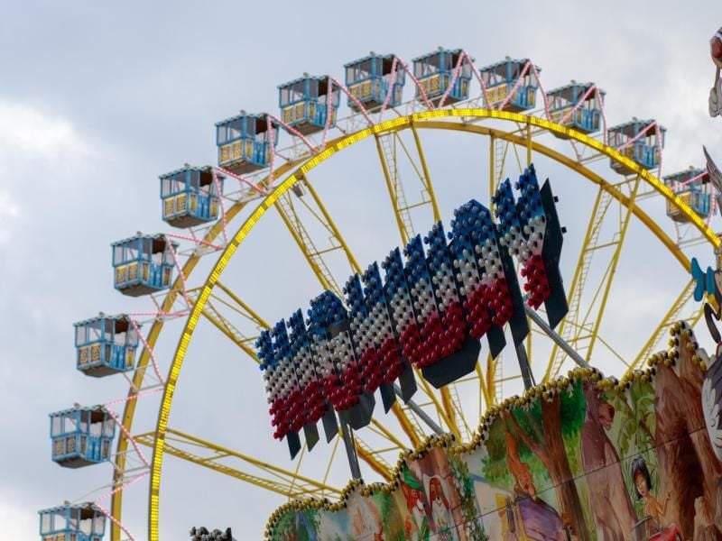 Ein Dom-Stand und ein Riesenrad stehen auf dem Hamburger Dom. Foto: Sina Schuldt/Archiv