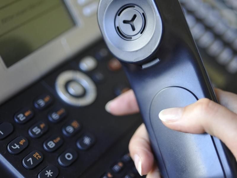 Eine Person hält einen Telefonhörer in der Hand. Foto: Marc Müller/Archiv