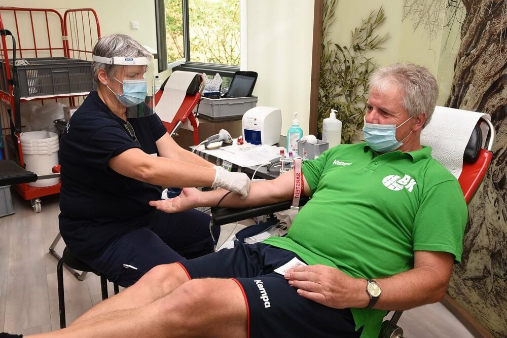 Mit Maske - aber sicher: DRK-Teamleiterin Claudia Schestow entnimmt HG 85-Trainer Bodo Kreutzmann die Blutspende im Köthener Helios-Klinikum.