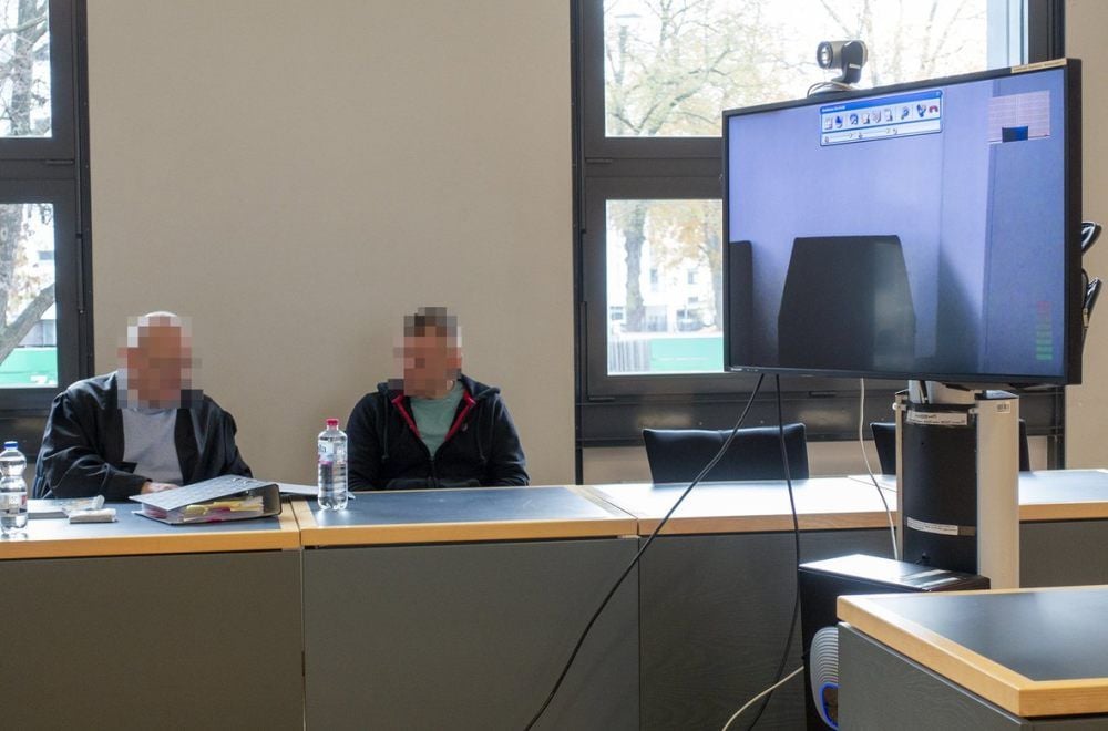 Der Angeklagte und sein Verteidiger vor dem Landgericht Magdeburg. Auf dem Bildschirm sollte später vermutlich die Befragung des mutmaßlichen Opfers gezeigt werden.