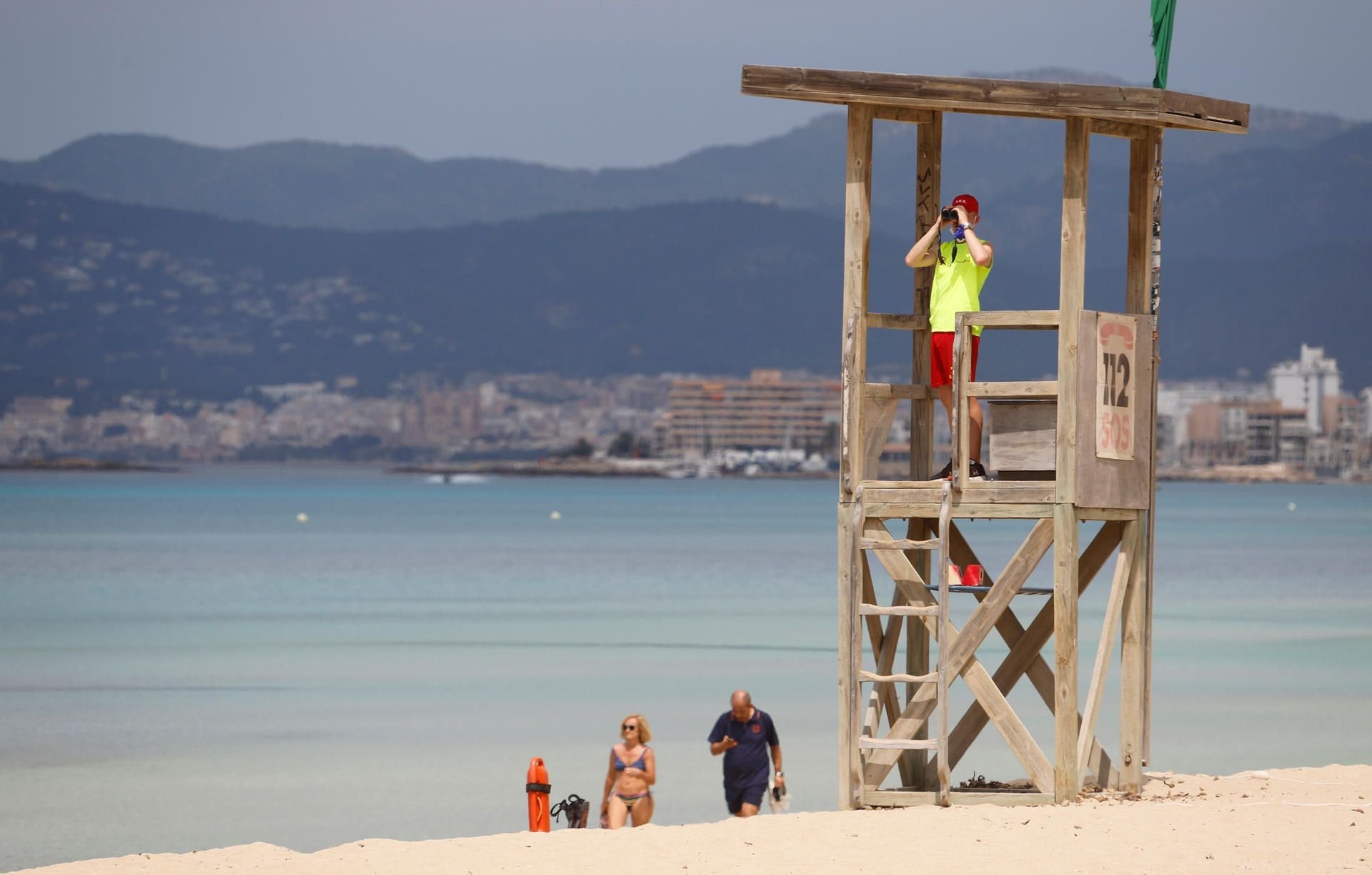 Ein Rettungsschwimmer beobachtet den Strand von Arenal. Nach dem Abflauen der Corona-Krise sollen deutsche Touristen als erste ausländische Urlauber wieder nach Spanien einreisen dürfen.