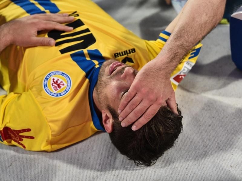 Braunschweigs Patrick Schönfeld wird während des Spiels gegen Nürnberg verletzt am Boden liegend behandelt. Foto: Nicolas Armer