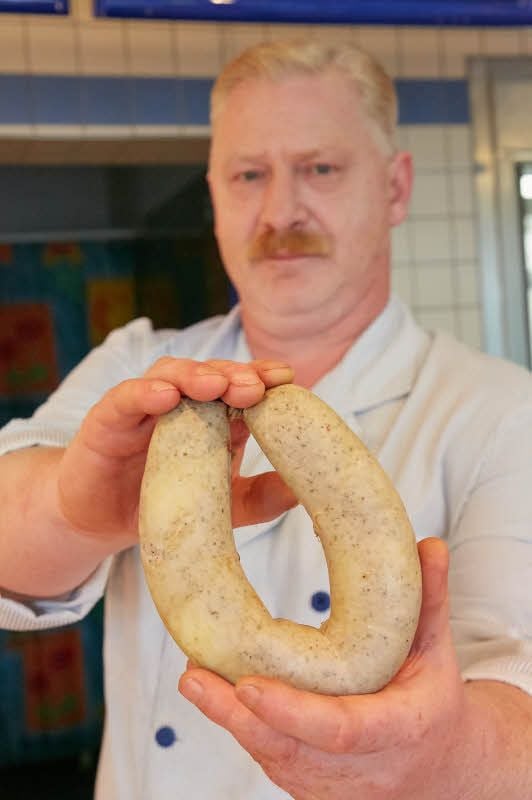 Geschäftsführer Peter-Henry Grimm zeigt die beliebte „Bernburger Zwiebelwurst“.