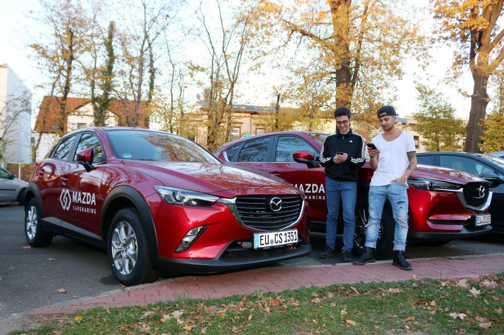 Philipp Sengupte (li.) und Koray Sendil sind Masterstudenten für Biotechnologie an der Hochschule Anhalt. Die beiden jungen Männer buchen ein Carsharing-Auto per Smartphone.