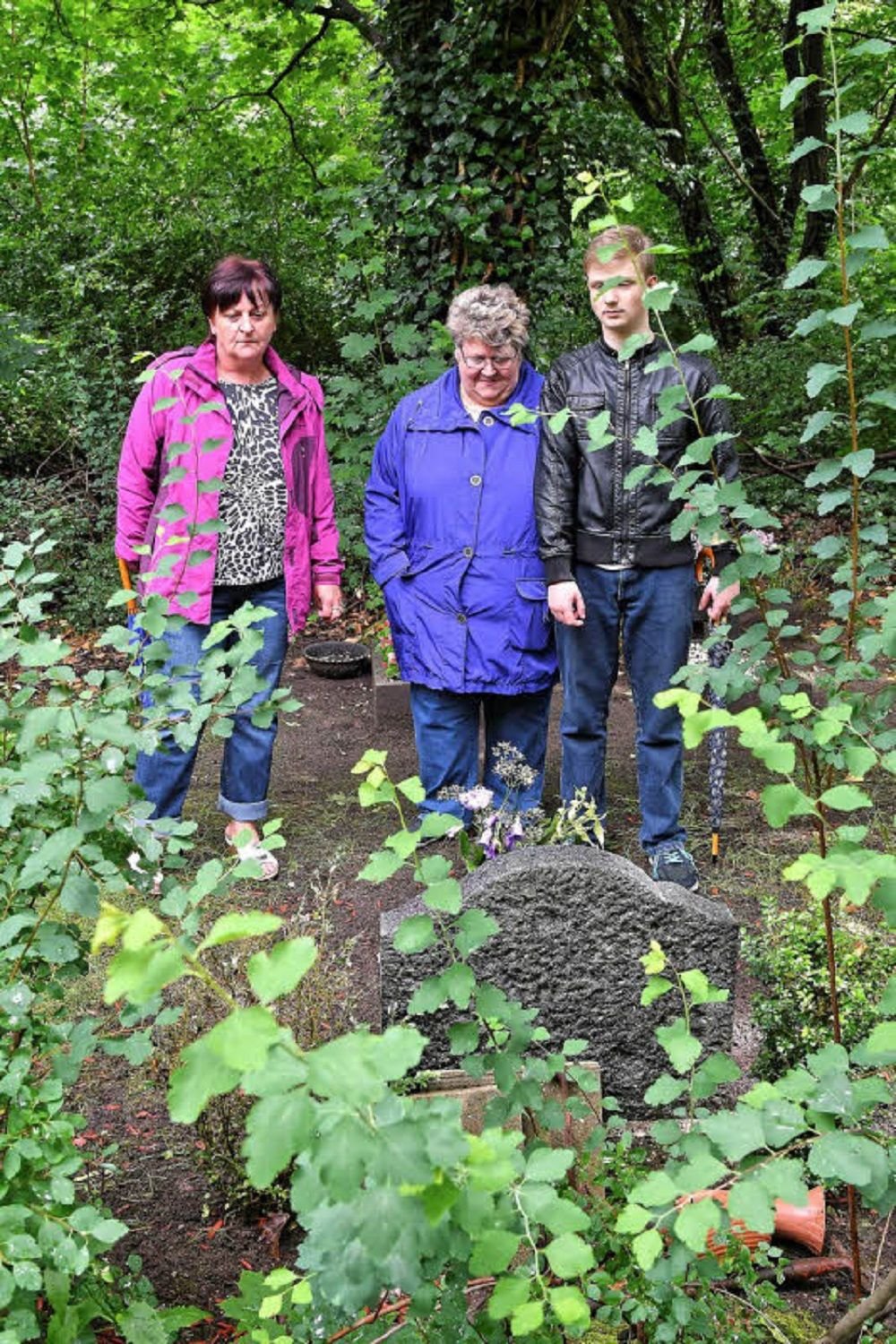 Ramona Lucas, Monika Osadchi und Justin Wünsche (v. li.) an den Gräbern ihrer Familienangehörigen.