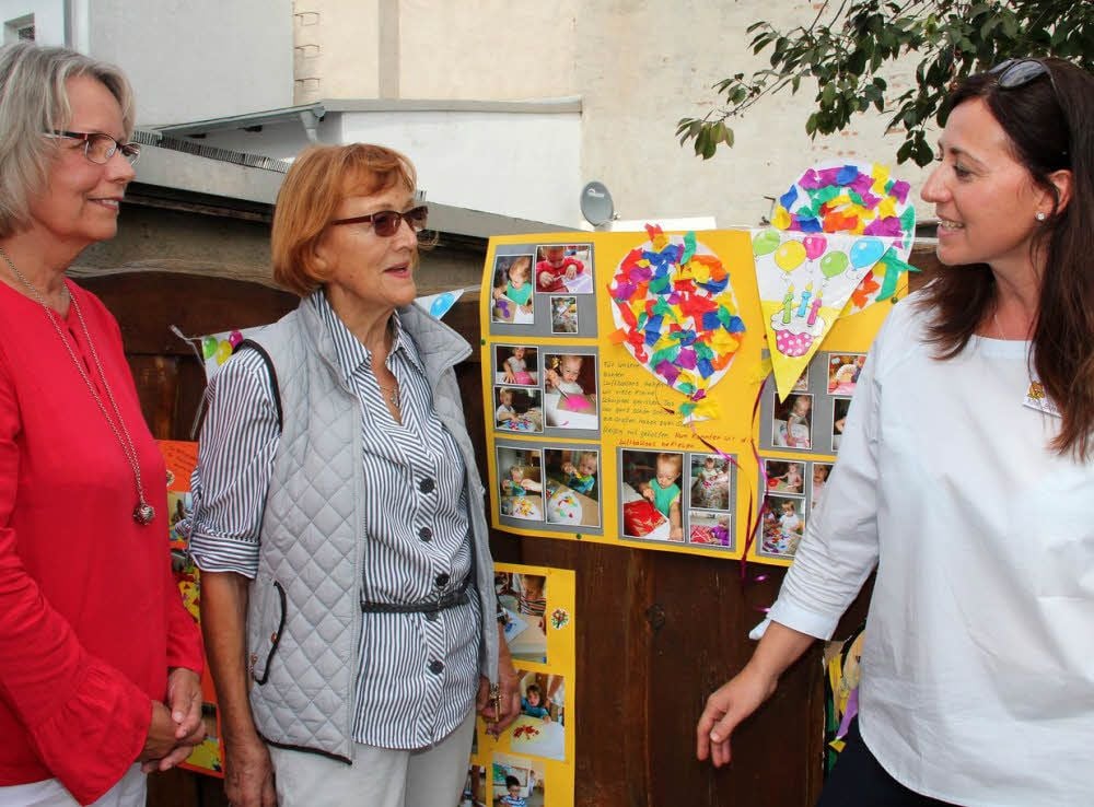 Margit Ahrendts, Leiterin von 1999 bis 2004, Mitte: Ursula Krüger, erste Leiterin der Tagesstätte, rechts Steffi Brückner, jetzige Leiterin von Bussi Bär, beim Gespräch und Ansehen der Fotos von früher und heute